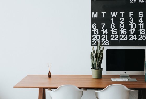 Desk with empty calendar and chairs suggesting unemployment and emptiness in blank space