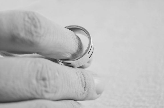 Removing wedding ring in conscious uncoupling move - hand and ring being separated