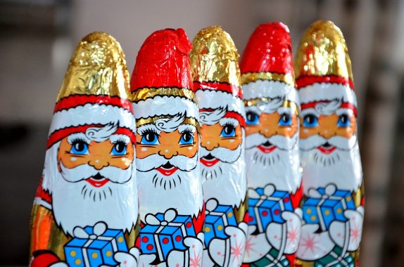 Santa Claus chocolate figurines in metallic foil, lined up macro shot