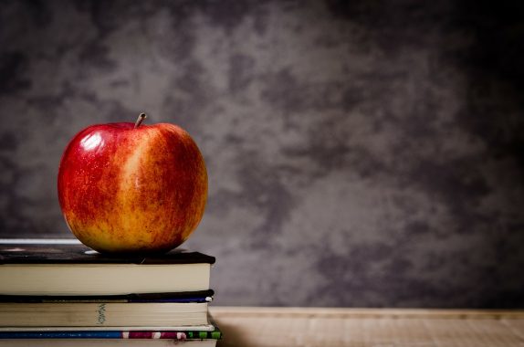 Back to school scene with desk, apple, blackboard and books. Typical school picture.