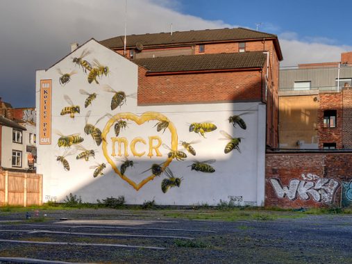 MCR heart with bees symbol of Manchester painted as mural on wall after Manchester terror attacks