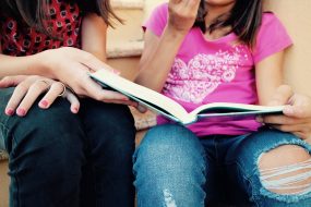 Family therapy with mother and child reading book together indoors