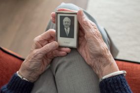 Older person looking at old photo in black and white from youth, showing memories and passing of time with Alzheimer's