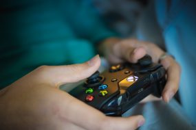 Gaming controls held by young person or teenager to indicate gaming disorder