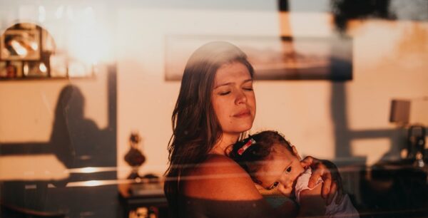 Mother and baby by window in sunlight