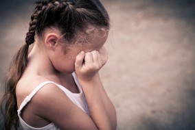 sad child with hand on her face