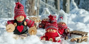 Christmas family of wooden dolls in snow with knitted outfits